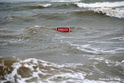 Flood waters almost cover a road sign